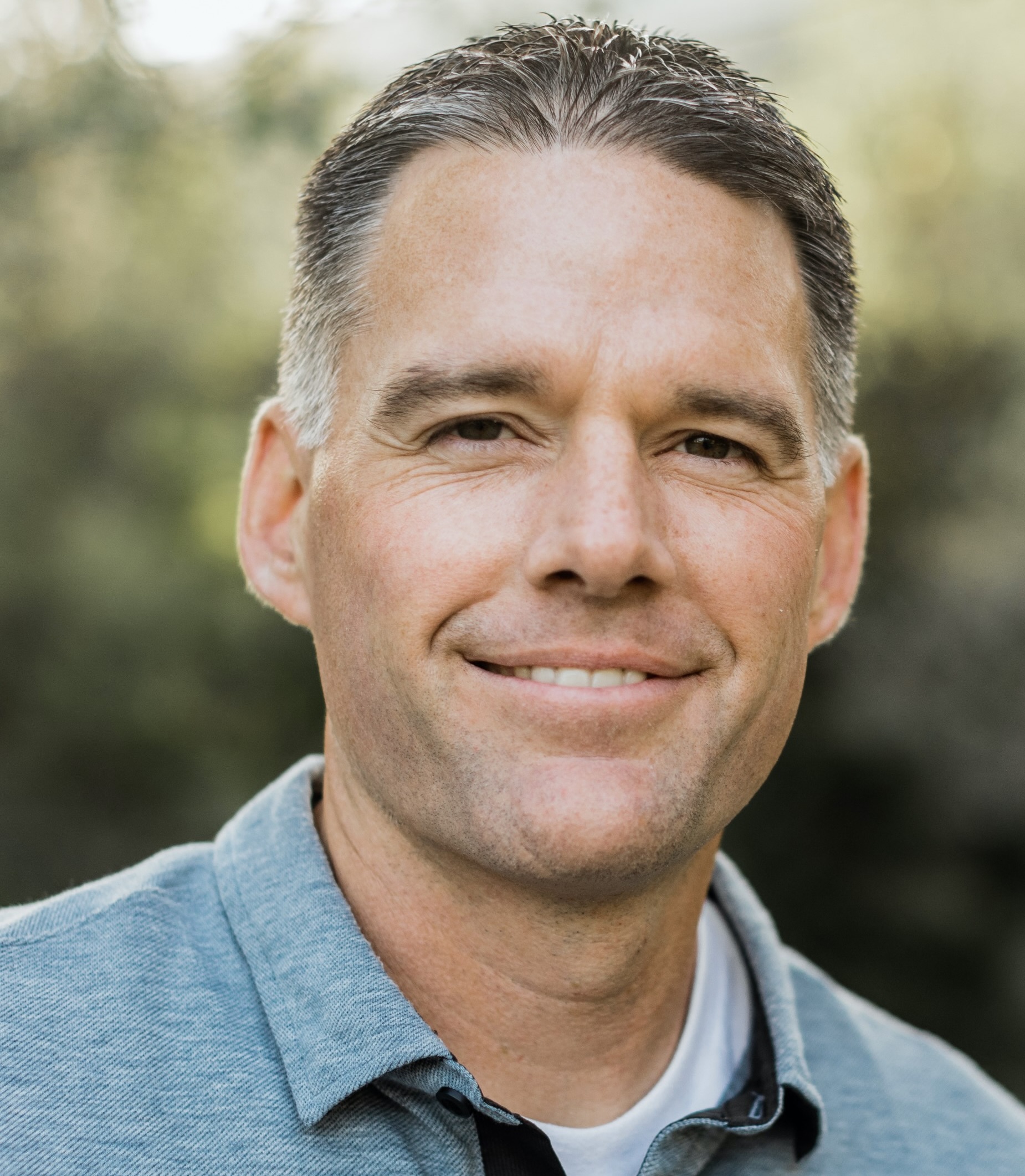 A person with a smile on his face sitting on a bench.